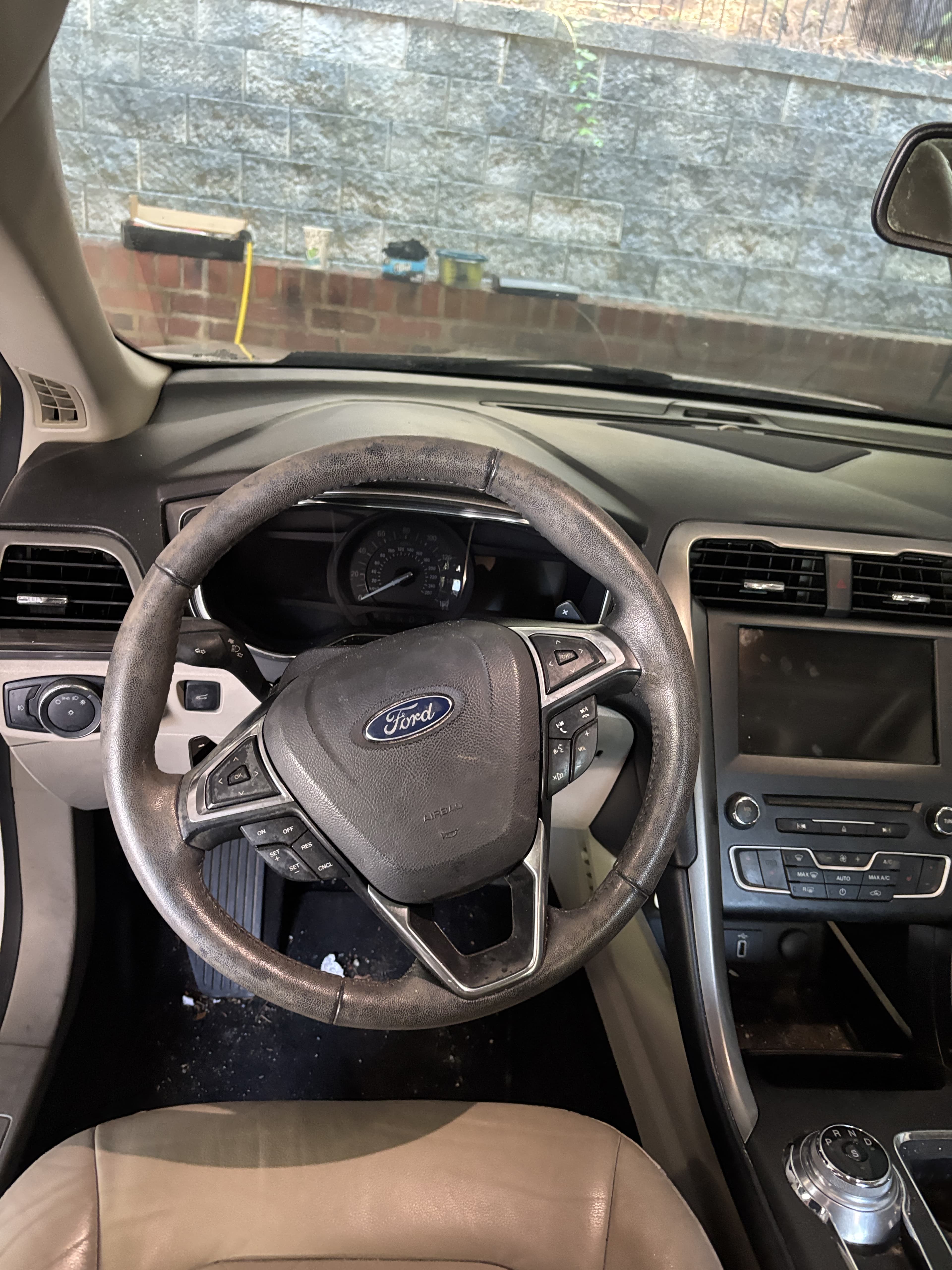 Interior view of a Ford car featuring a worn steering wheel and modern dashboard controls.